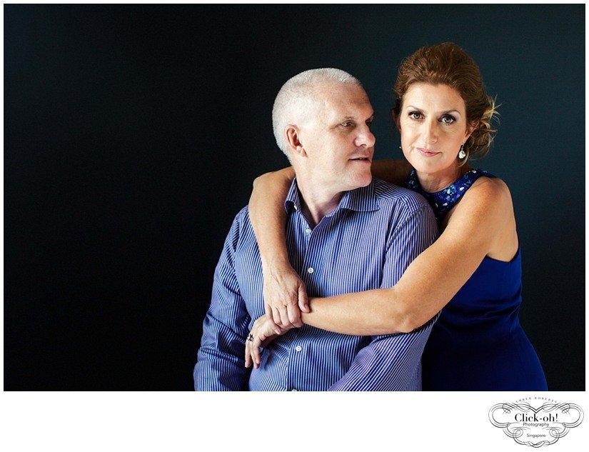glamorous couple in blue embraces in studio photo