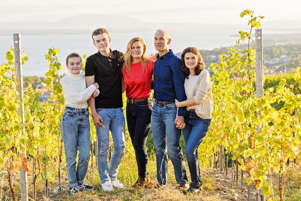 Family standing in vineyard at golden hour