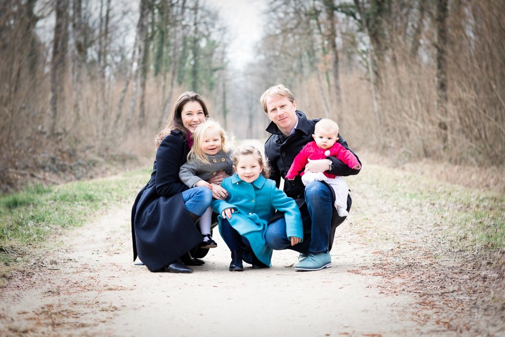 family poses for a photo in outdoor winter family photo shoot with toddlers