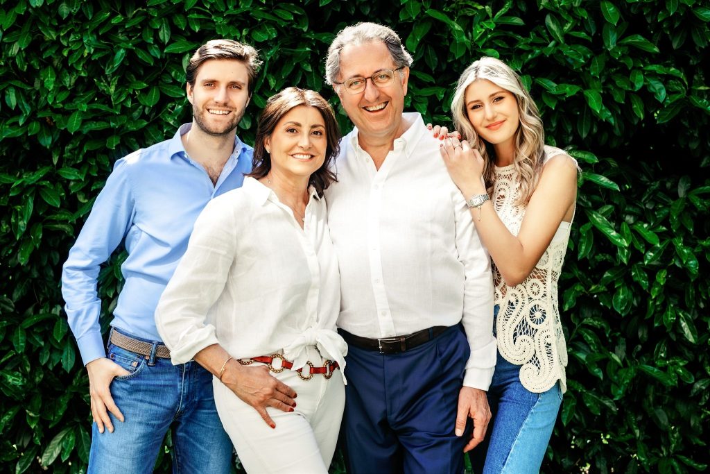 Photo of a family with 2 adult children posing outside during a family photo shoot