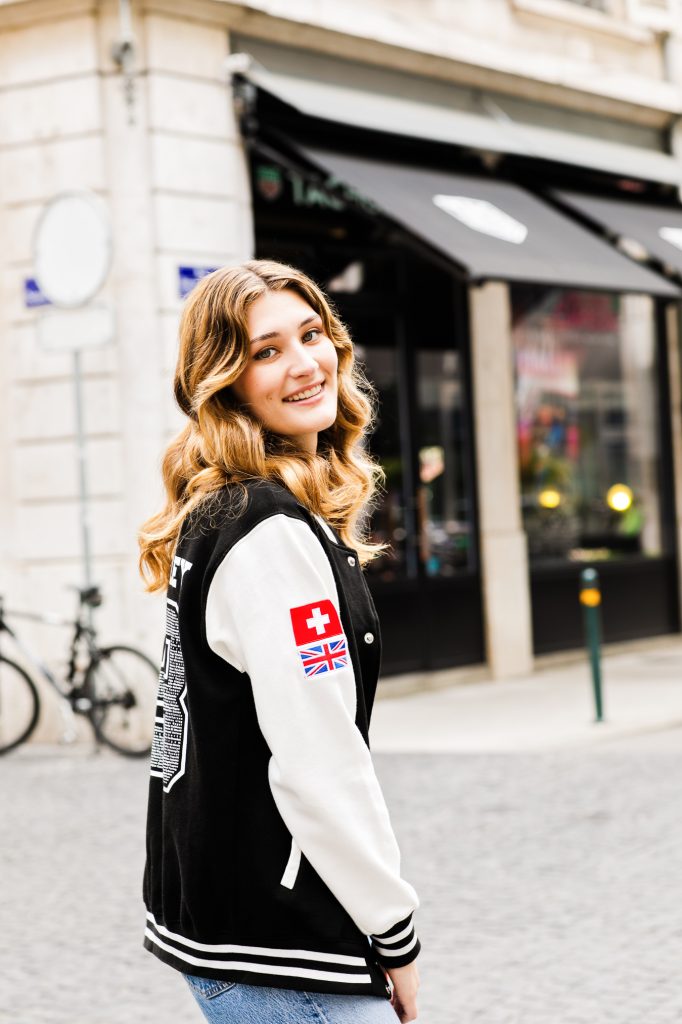 Geneva Switzerland High School senior girl wears varsity jacket during photo shoot