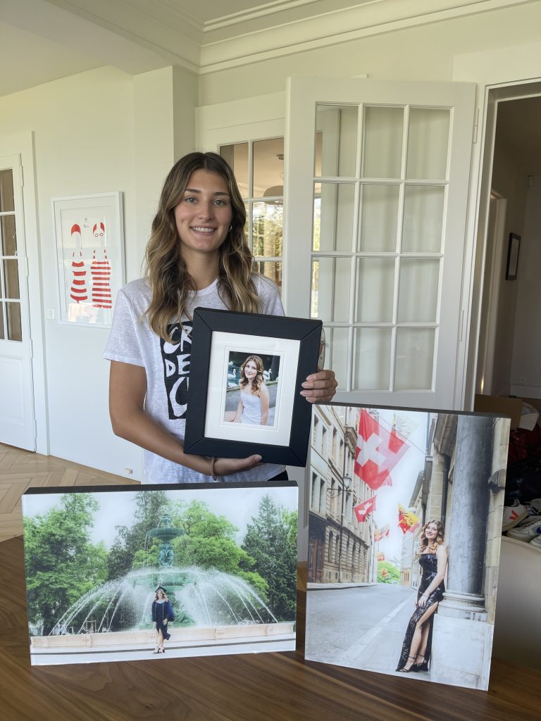 Image of Senior High School graduate in Geneva Switzerland holding her senior photos and wall art